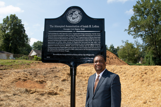 Associate Professor Tony Lowe next to the Isaiah H. Lofton historic marker.